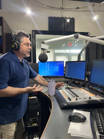 A presenter broadcasting live in a radio studio