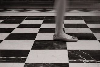 Foot on a black and white checkered floor.