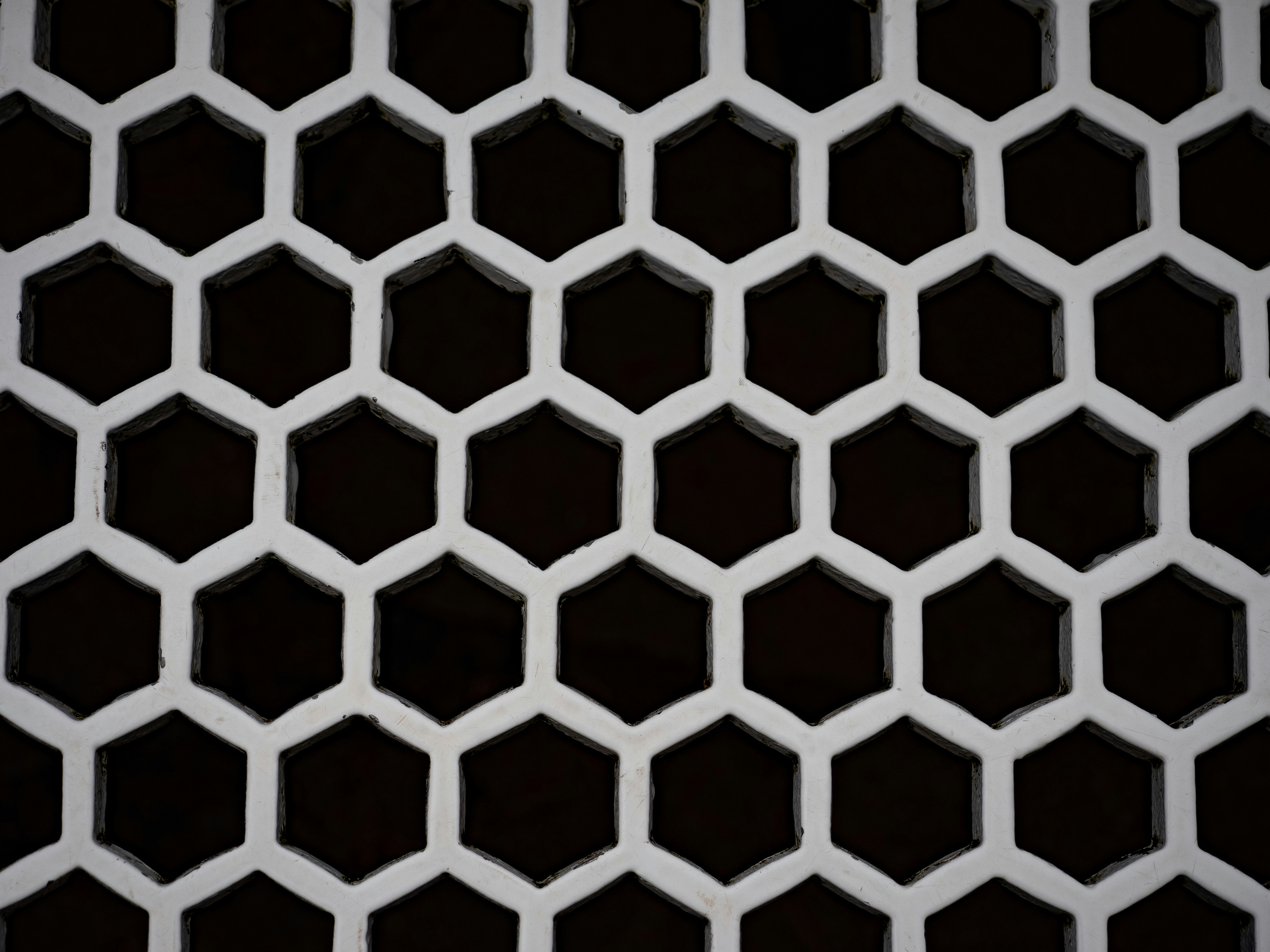 Un patrón blanco de panal sobre fondo oscuro.