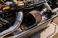 Cold-air intake tube and cone filter installed across the front of a performance engine bay