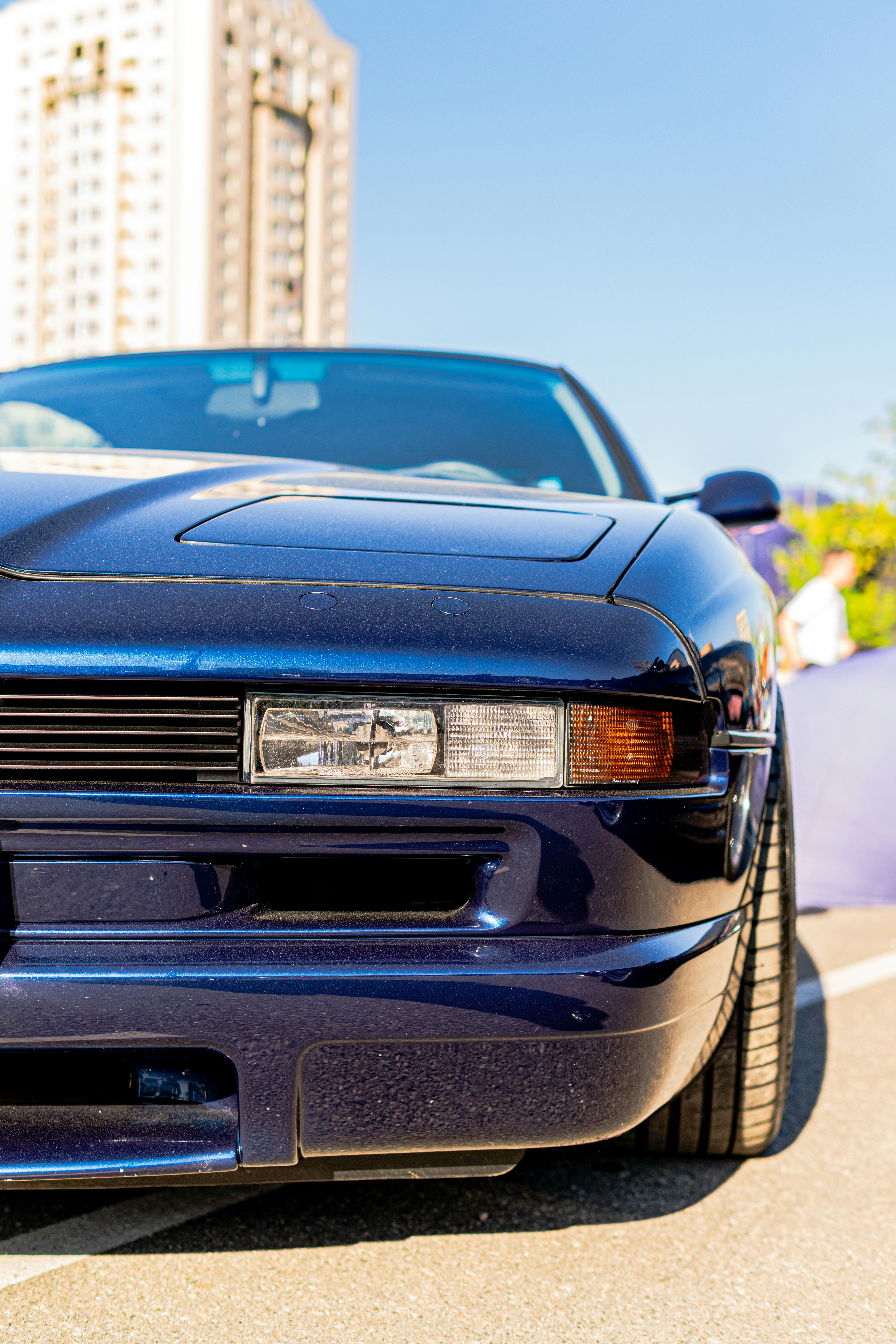 Dark blue sports car's front right side in urban setting