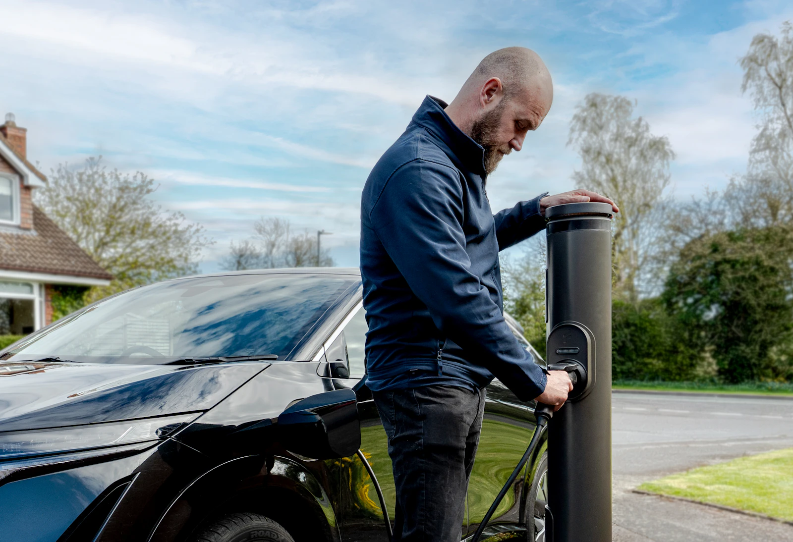 Un automobiliste recharge son véhicule électrique sur une borne extérieure
