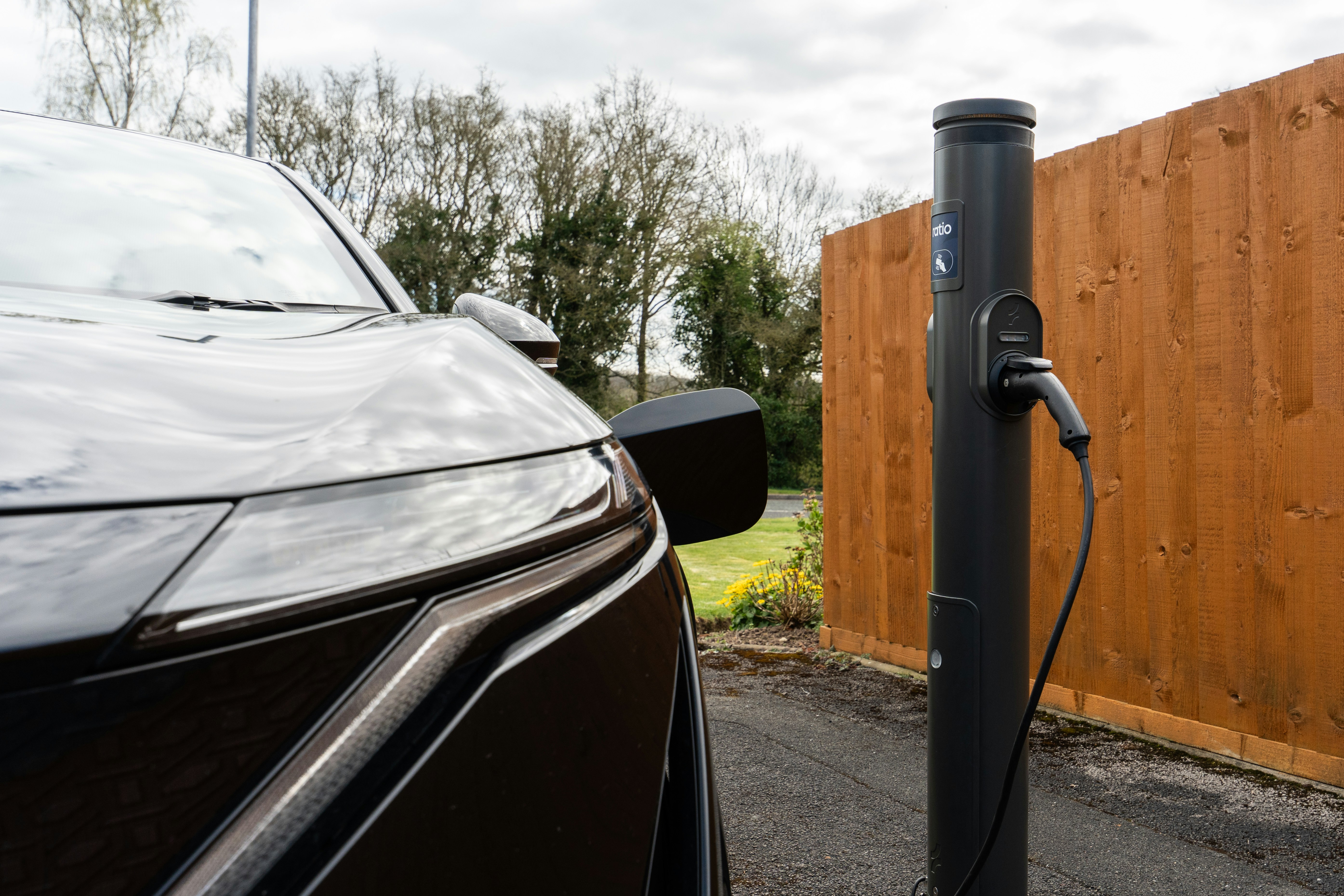 electric car charging at charging station - Modern electric car plugged into a charging station.