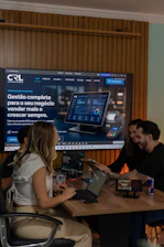Colleagues collaborating around a table with a large screen display.
