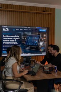 Colleagues collaborating around a table with a large screen display.