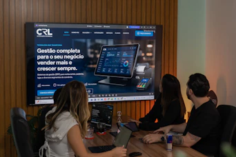 Three colleagues viewing a business presentation on a large screen.