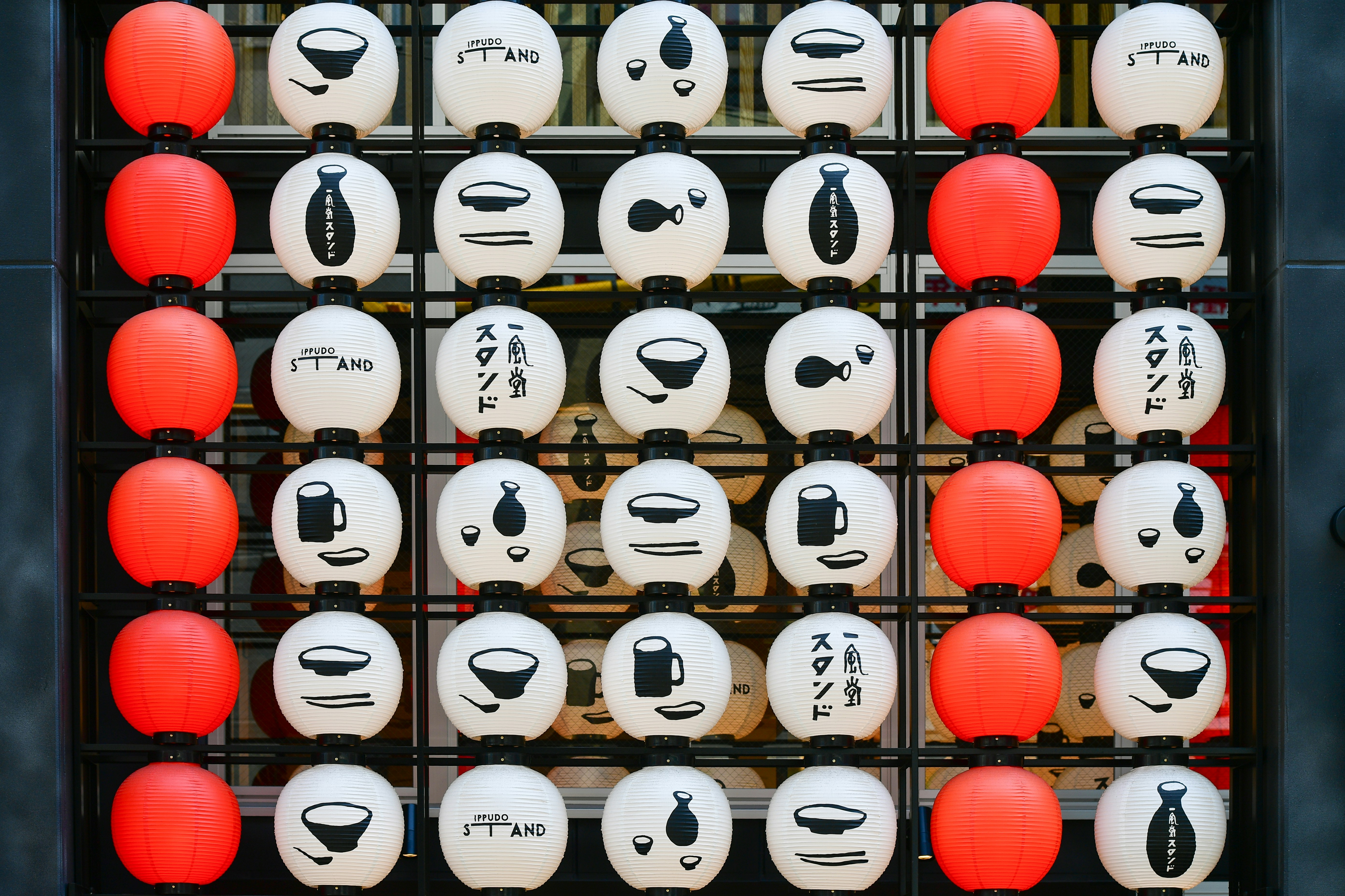 Close-up of a neatly arranged weekly mansion kitchen counter in Japan showing small rice cooker, microwave, kettle and basic cooking utensils on clean white surface