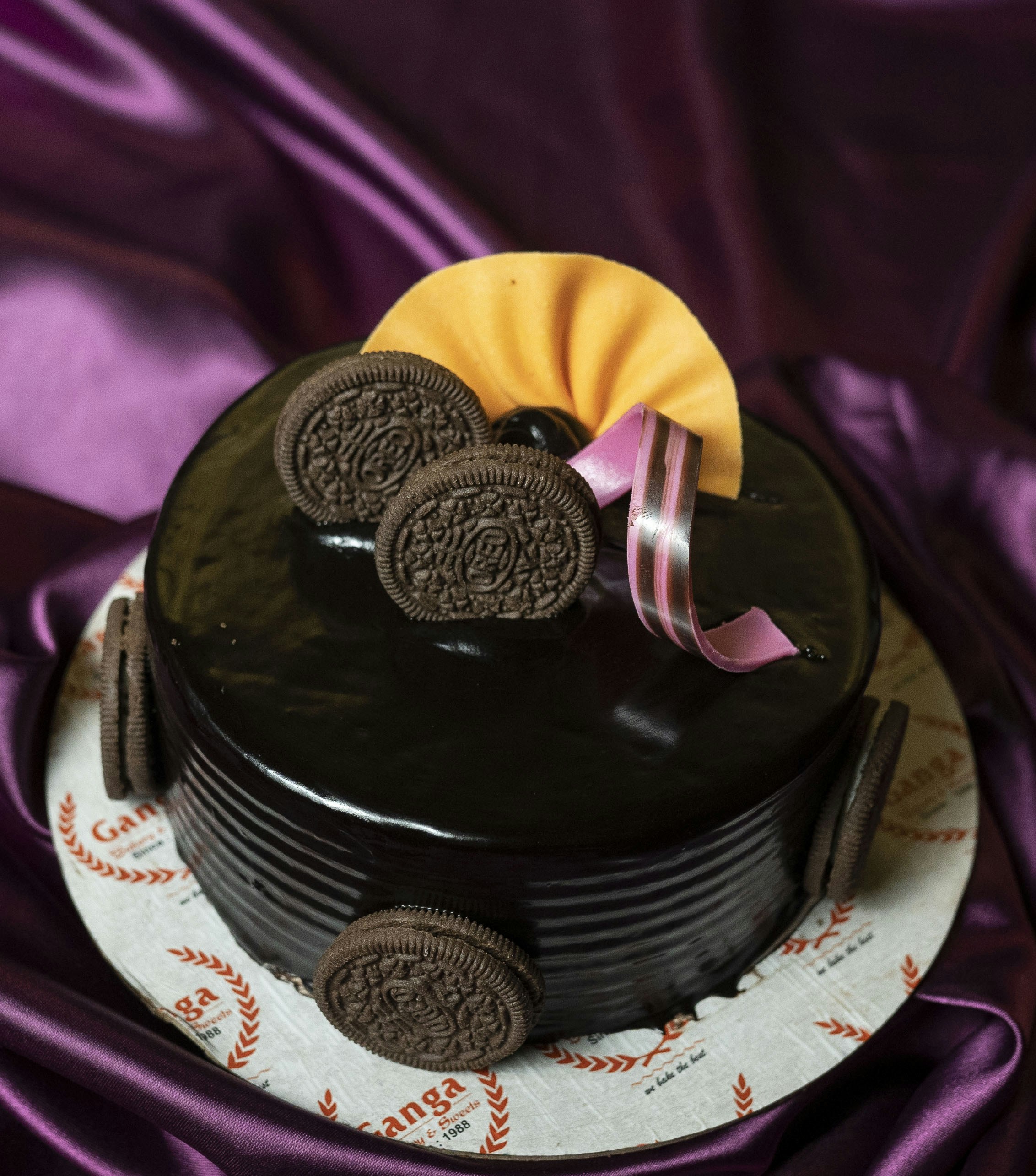 A decadent chocolate cake adorned with oreo cookies and ribbons. photo ...