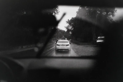 Rainy drive from inside a car on a wet road.