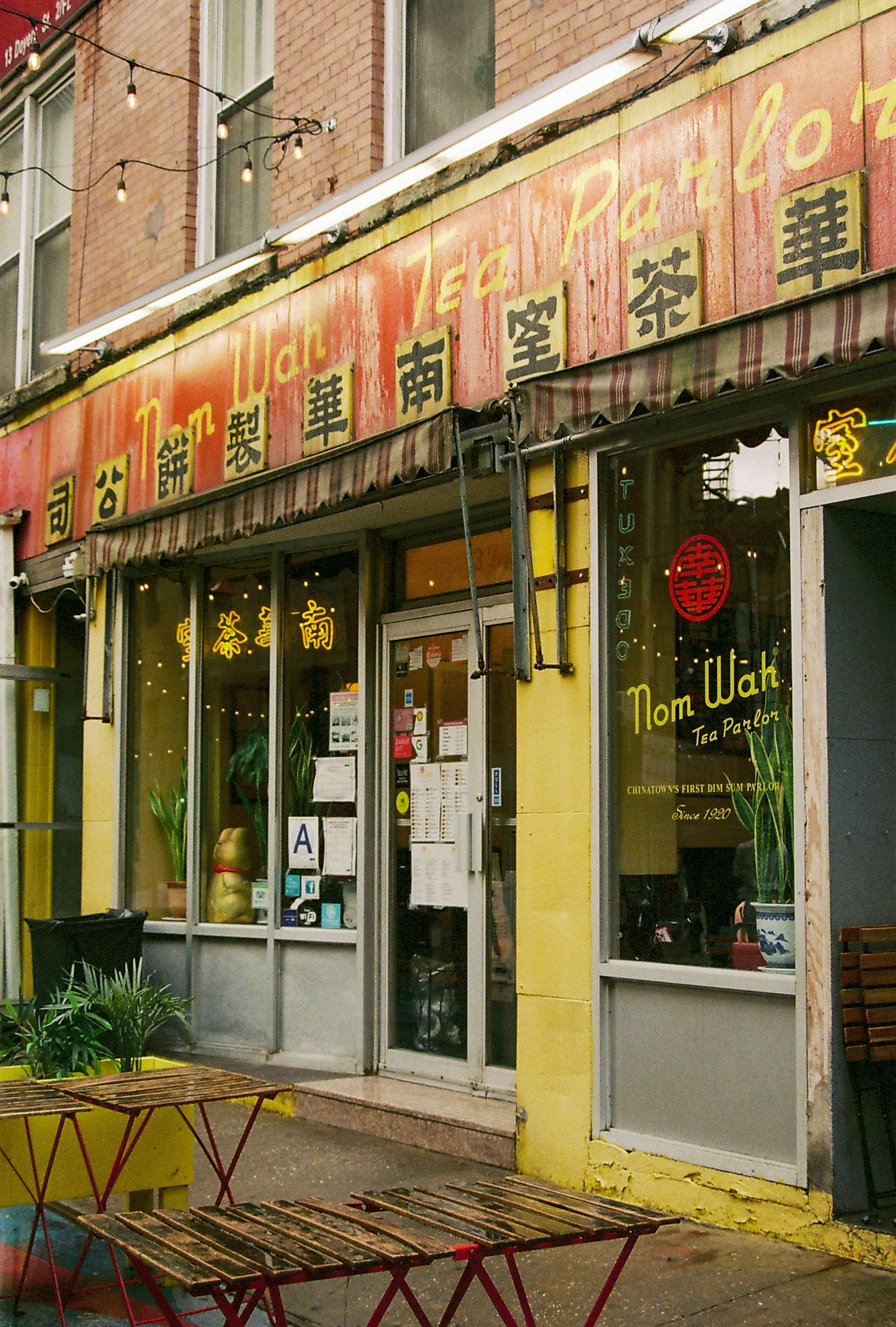 The exterior of nom wah tea parlor with outdoor tables