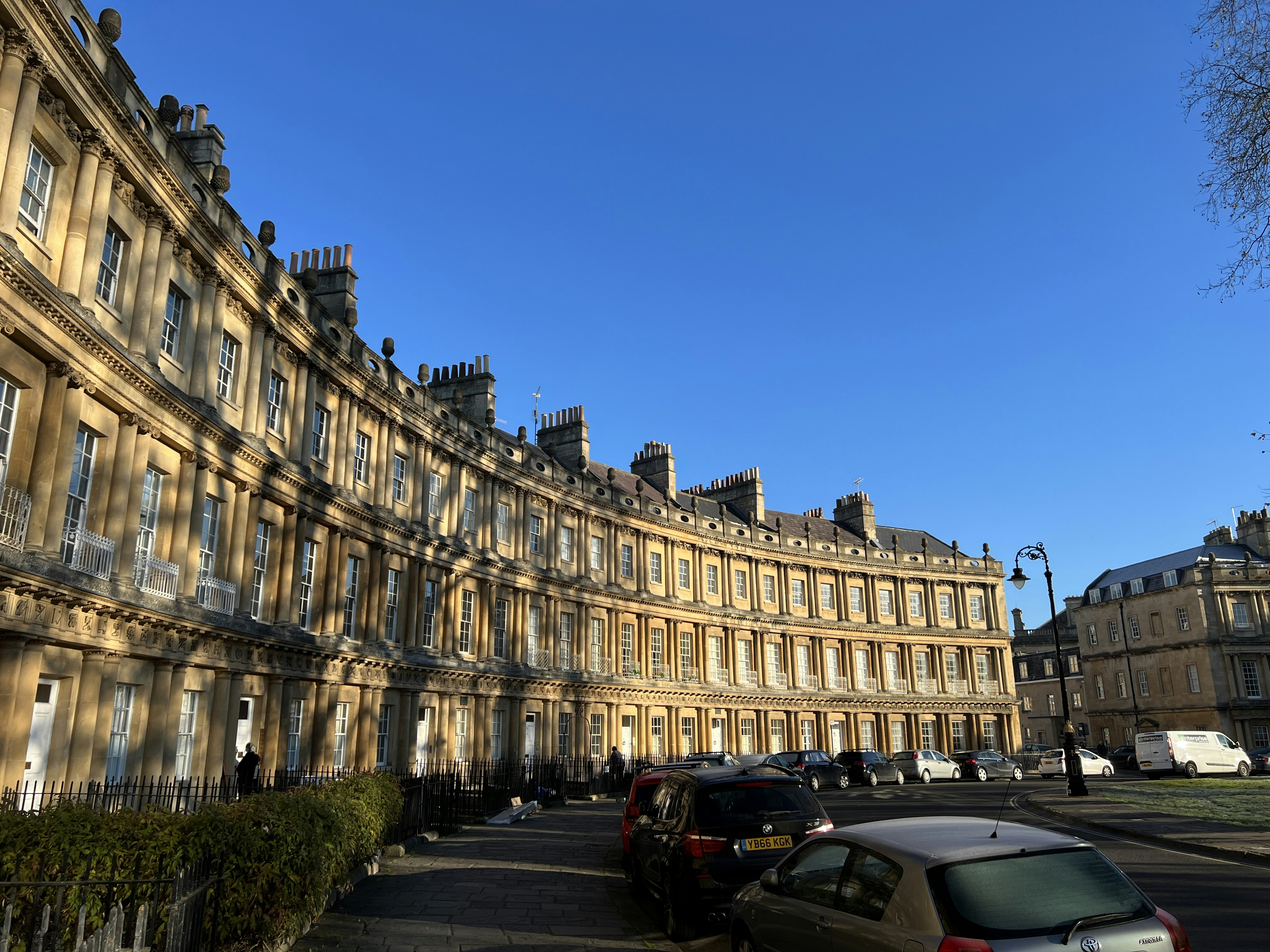 Historic curved stone buildings under a clear blue sky.