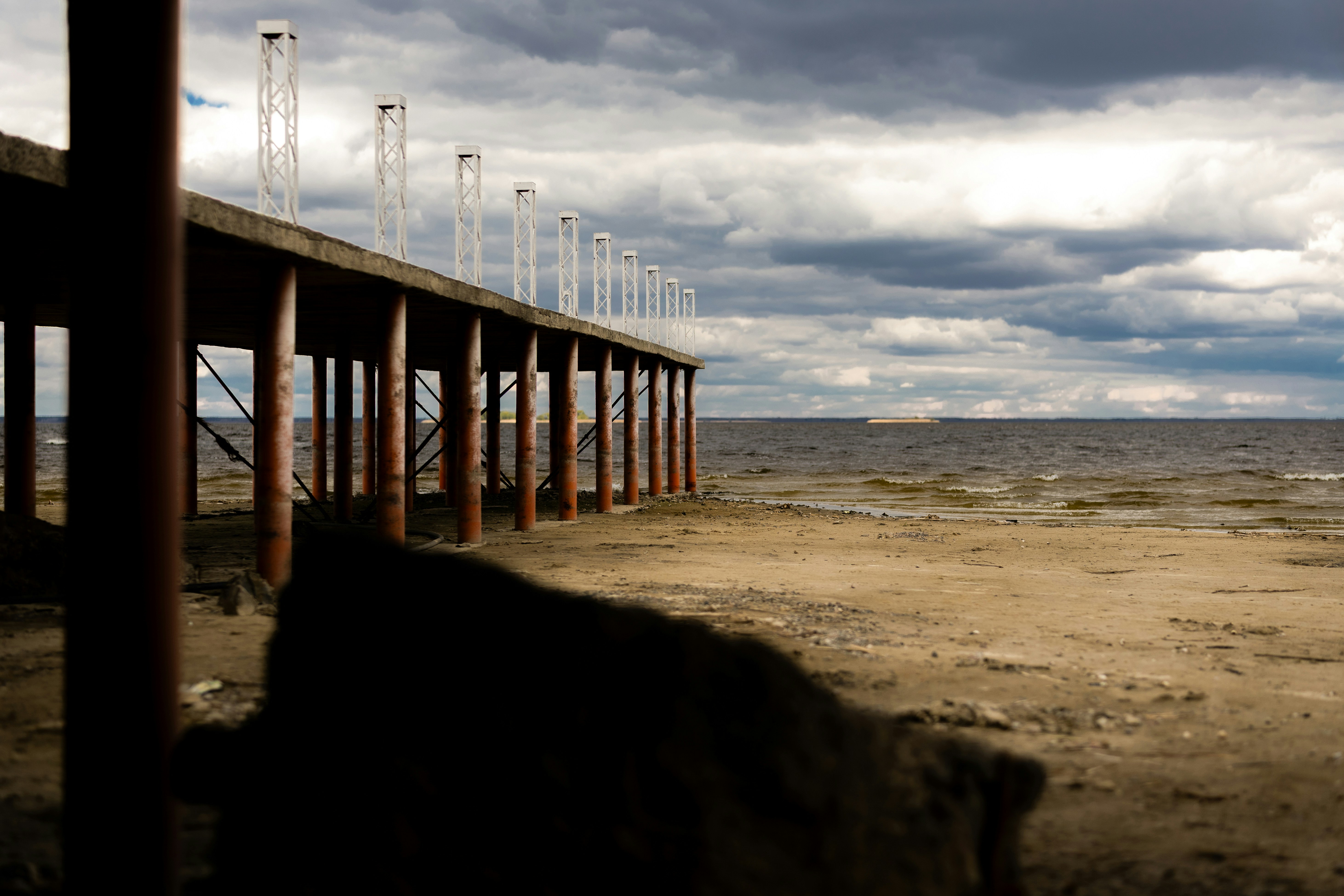 Weathered pier stretches into the sea beneath a dark sky