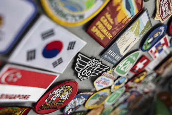 Colorful travel patches and magnets featuring flags and destinations.