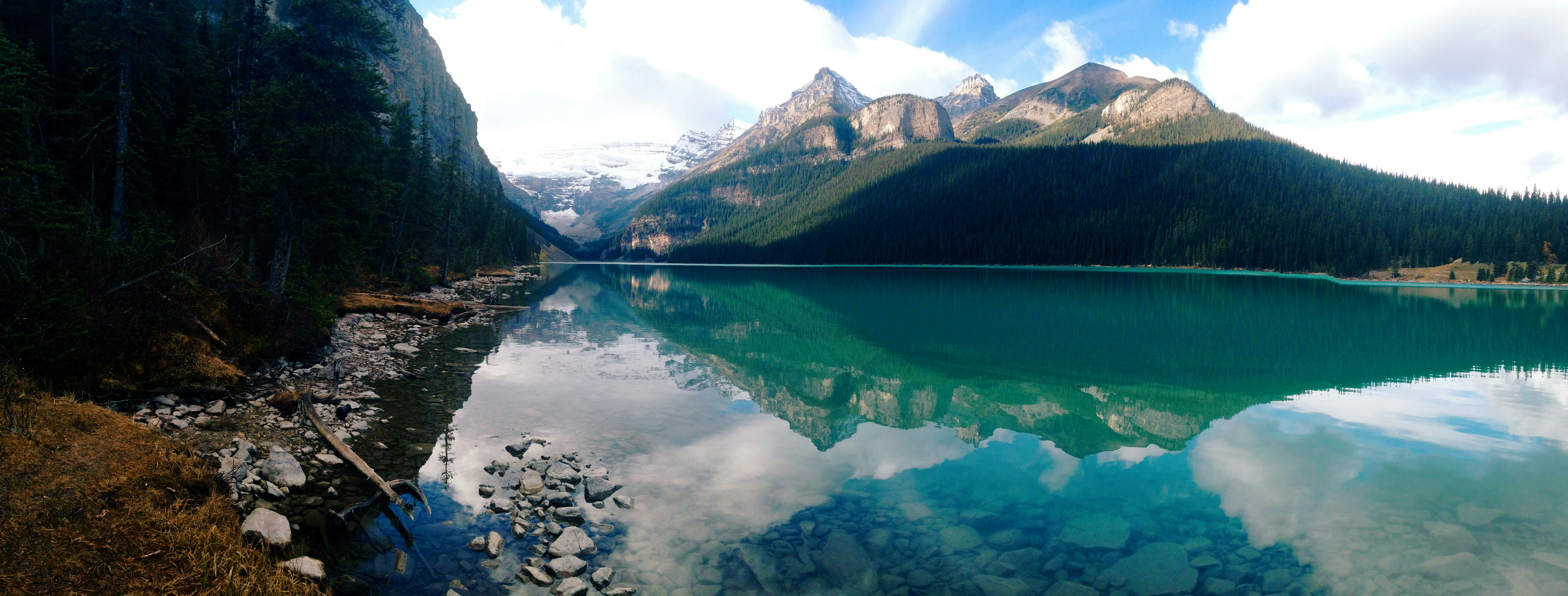 A serene mountain lake reflects peaks and sky.