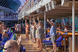 People raising hands on a sunny cruise ship deck