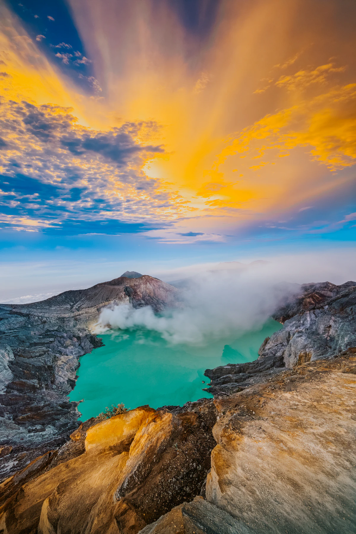 Vivid turquoise sulfur acid lake and midnight blue fire inside Kawah Ijen