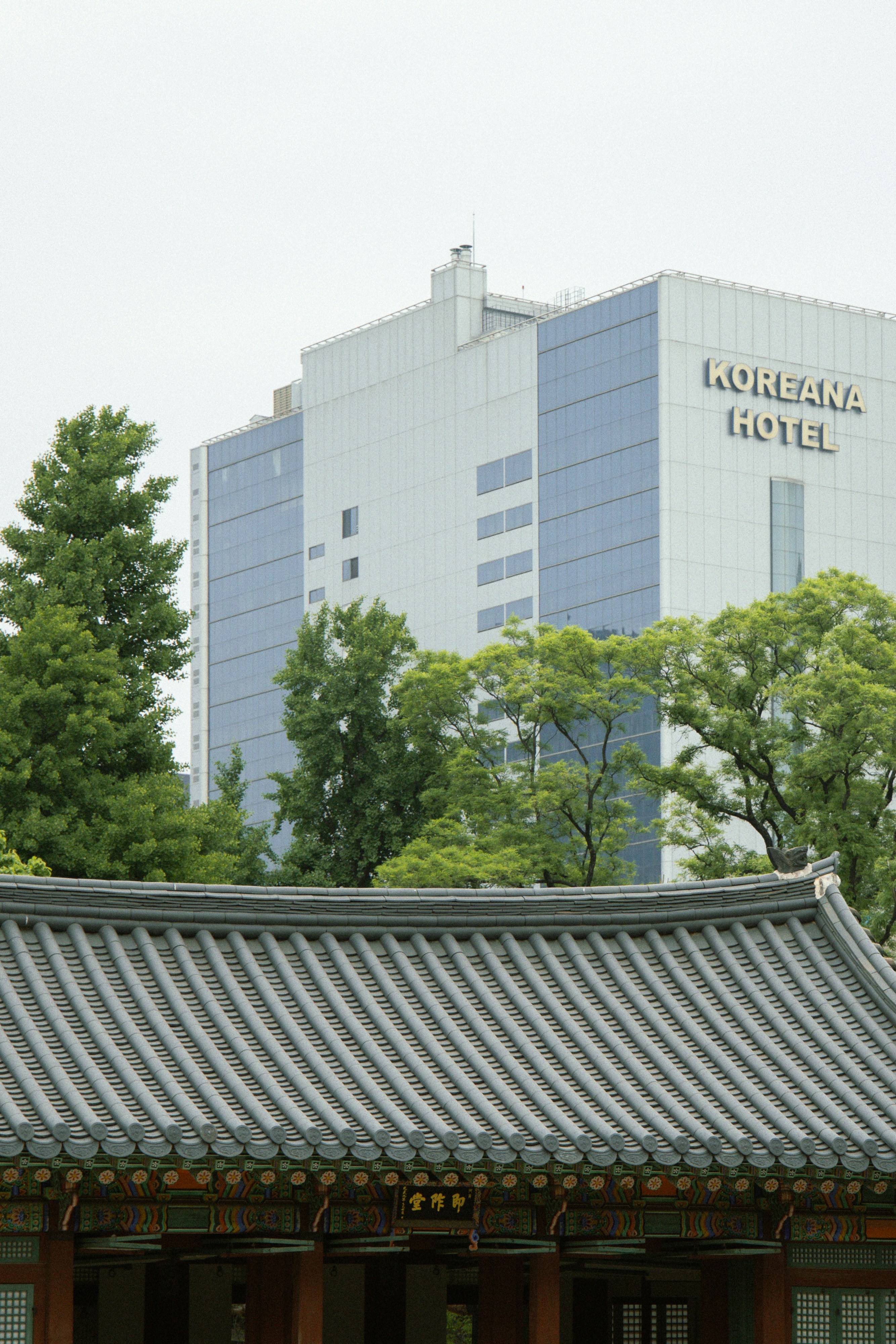 O edifício moderno do hotel coreano tem vista para um telhado tradicional coreano.