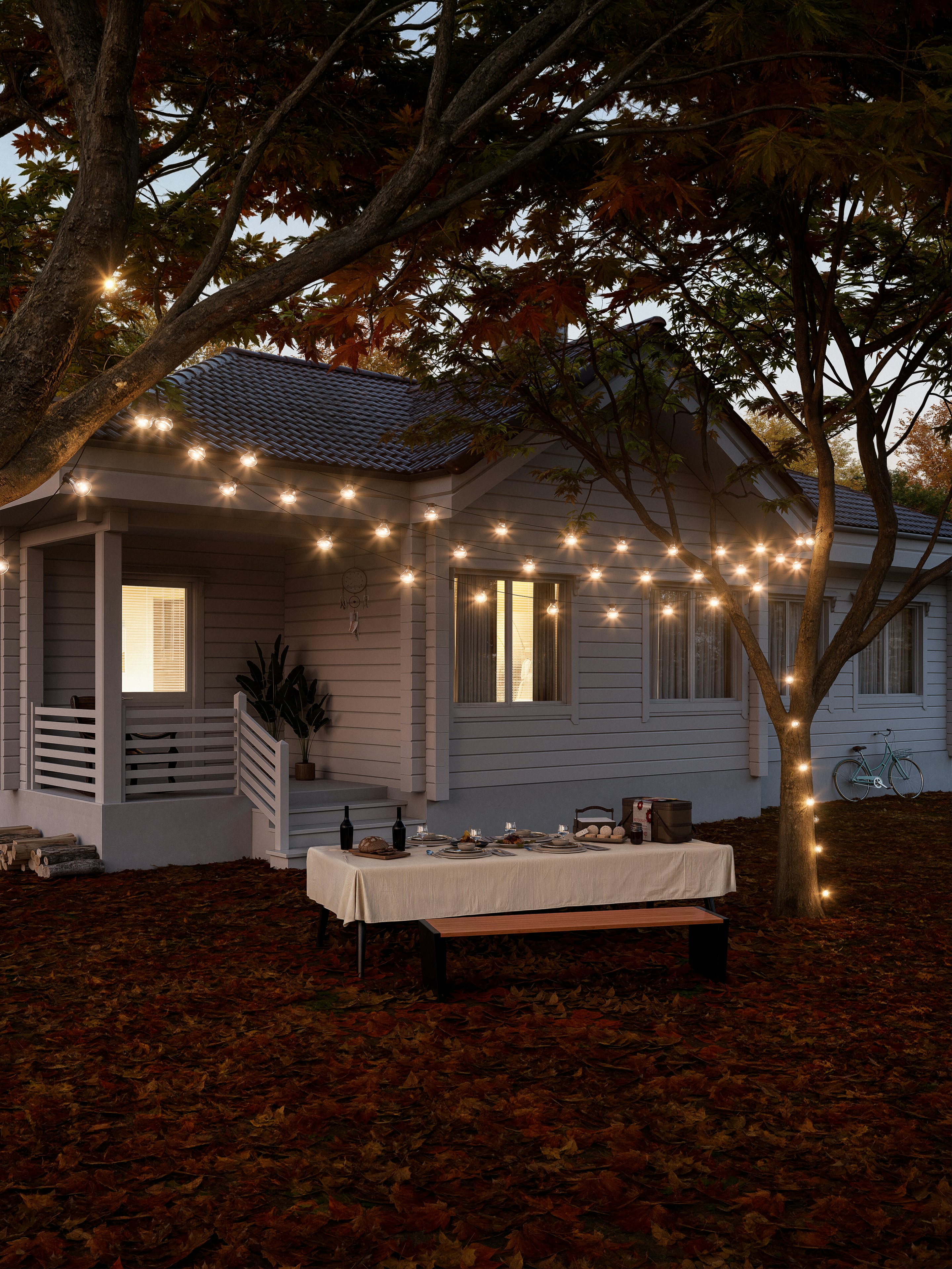Cozy backyard dinner setup with string lights and autumn leaves.