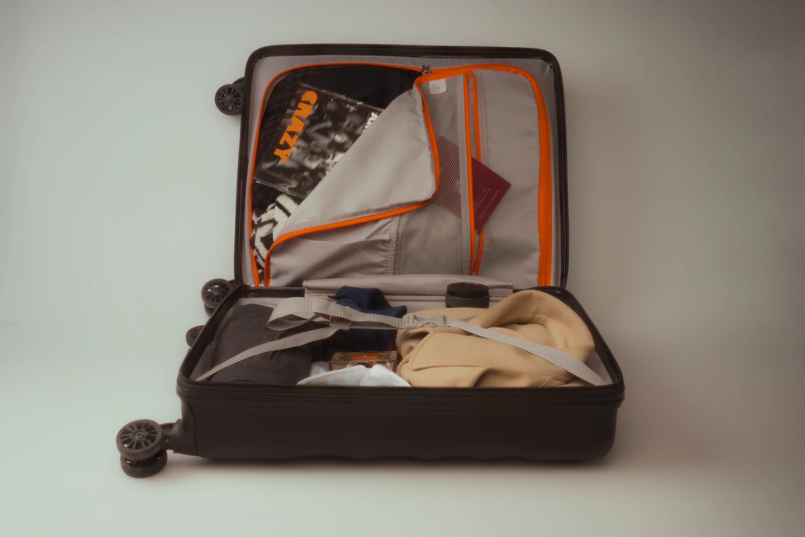 An open carry-on suitcase packed neatly with clothes and travel essentials