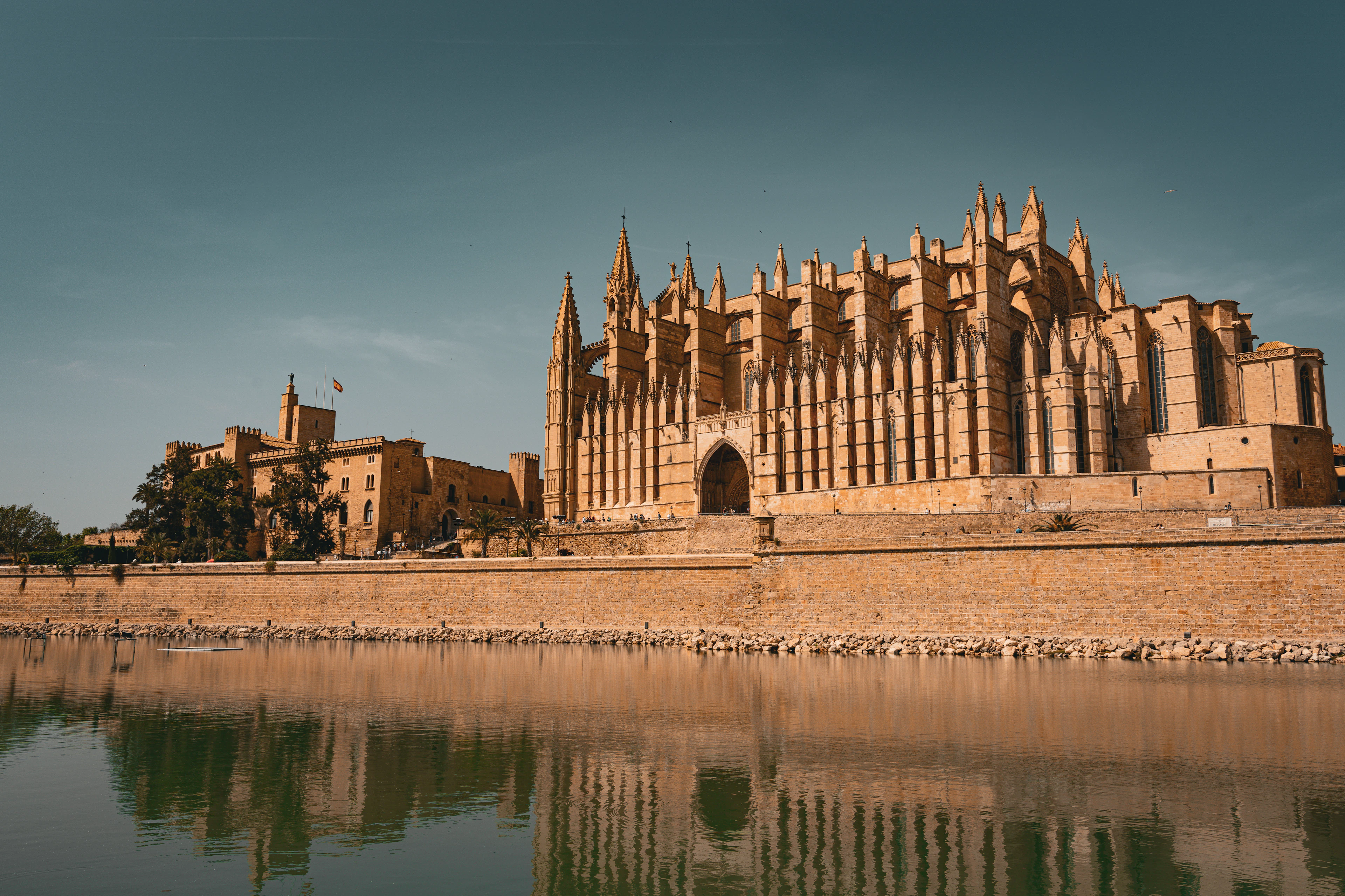 Palma Cathedral and the old city walls of Mallorca reflected in the still water of the Parc de la Mar lake