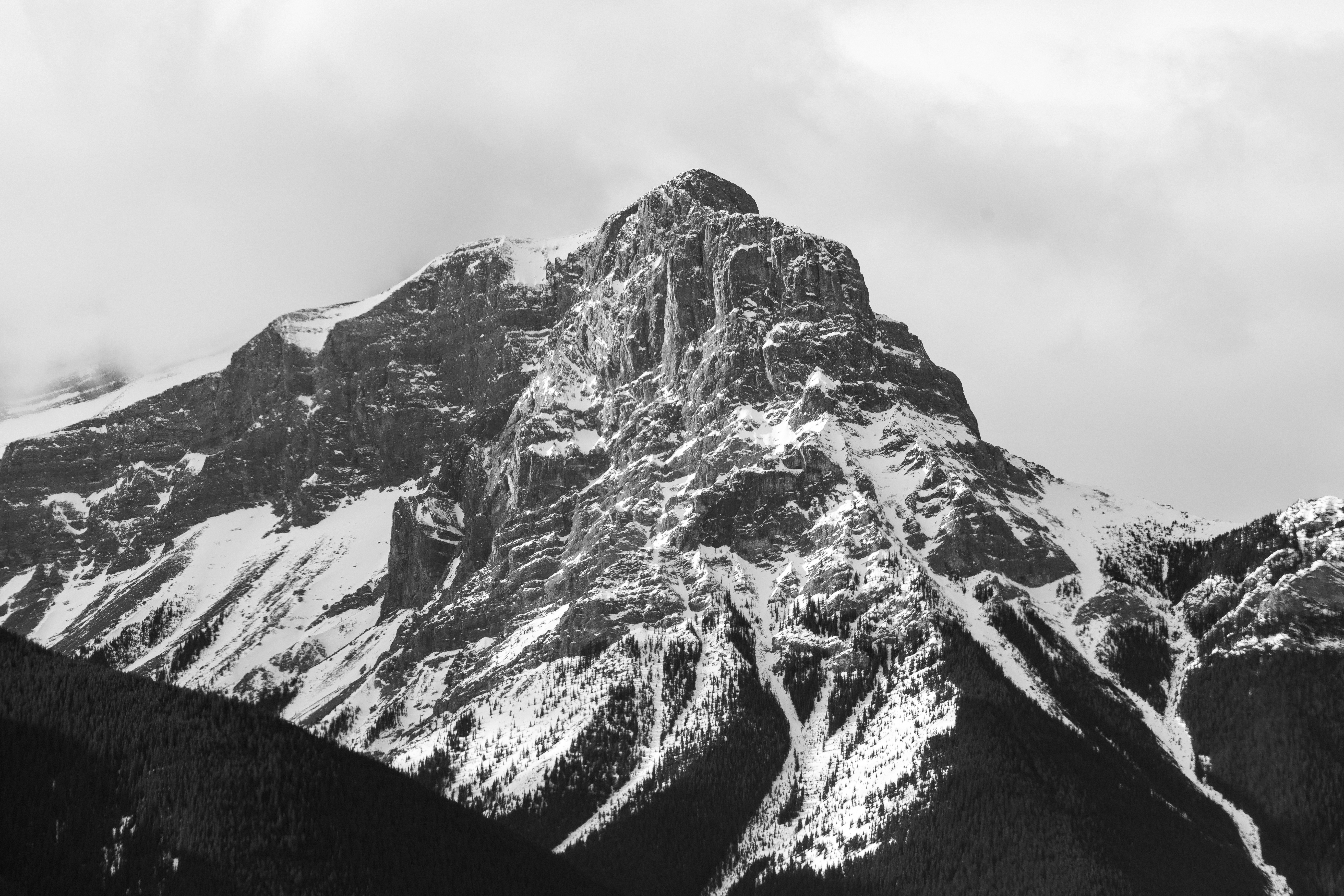 Majestosa montanha coberta de neve contra um céu nublado.