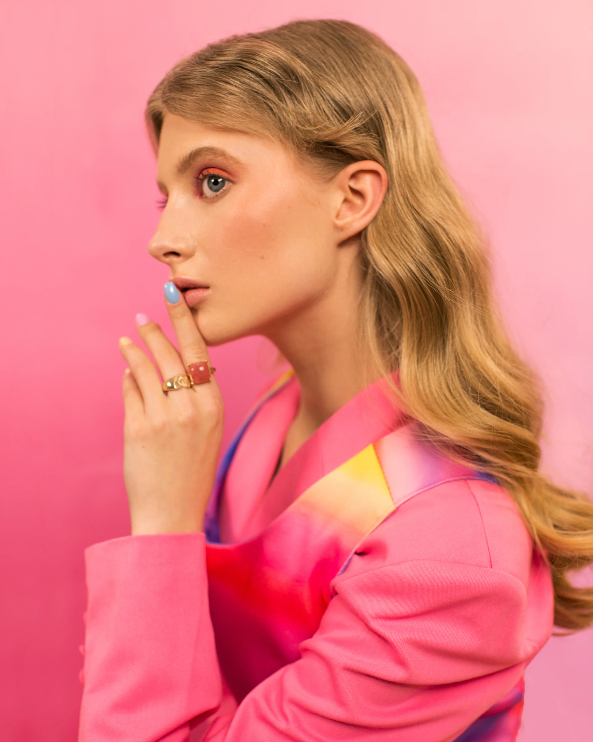 Profile of a young woman in a vibrant pink blazer.