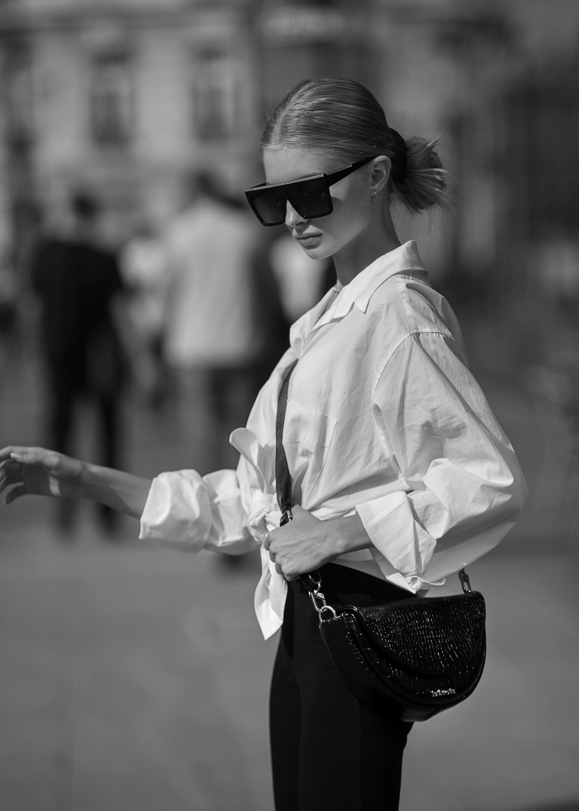 Stylish woman in sunglasses and white shirt on a street