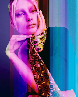 Woman with pink hair and scarf in dramatic, colorful lighting