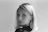 Blonde woman with earrings looking directly at viewer.