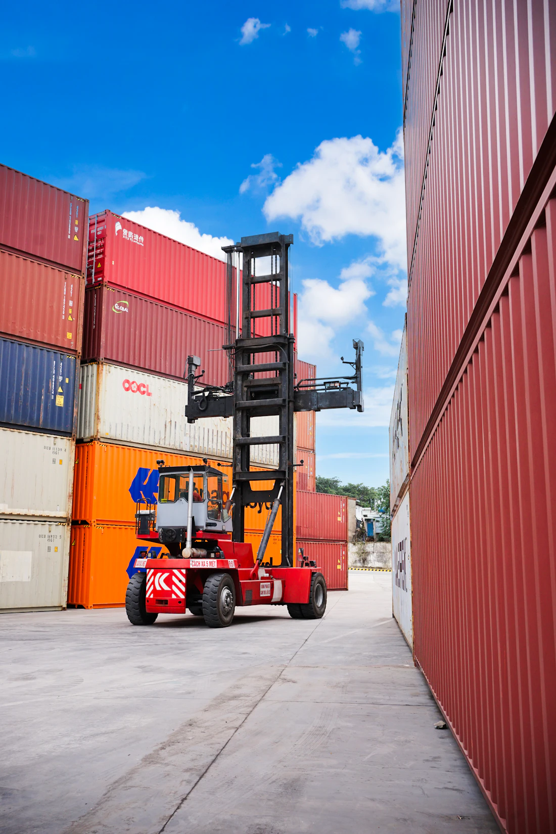 Reach stacker moving containers in a yard
