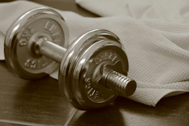 Chrome dumbbell and towel on dark wood