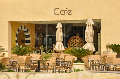 Cafe exterior with outdoor seating and beige umbrellas