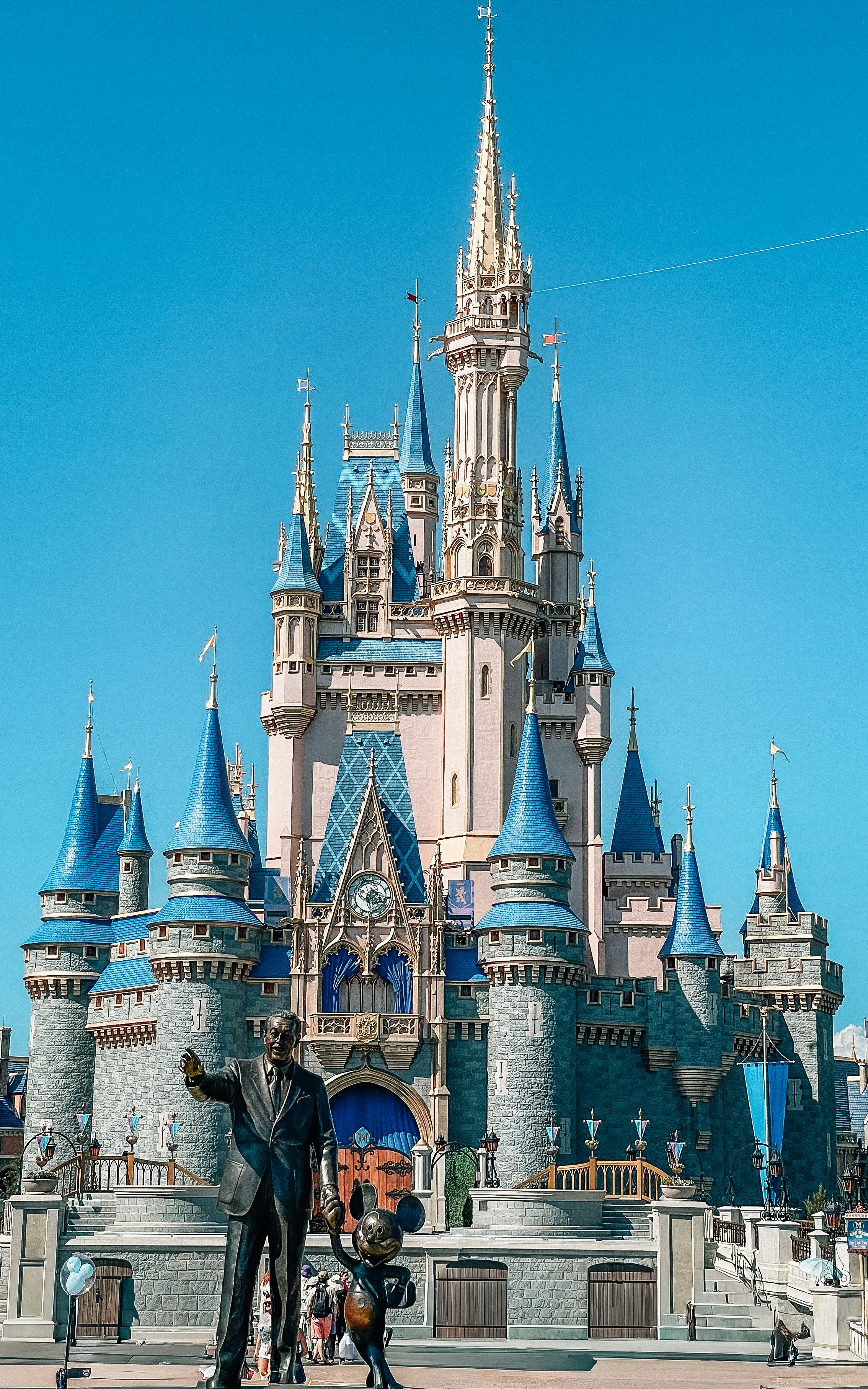 Cinderella castle with walt disney and mickey mouse statue.