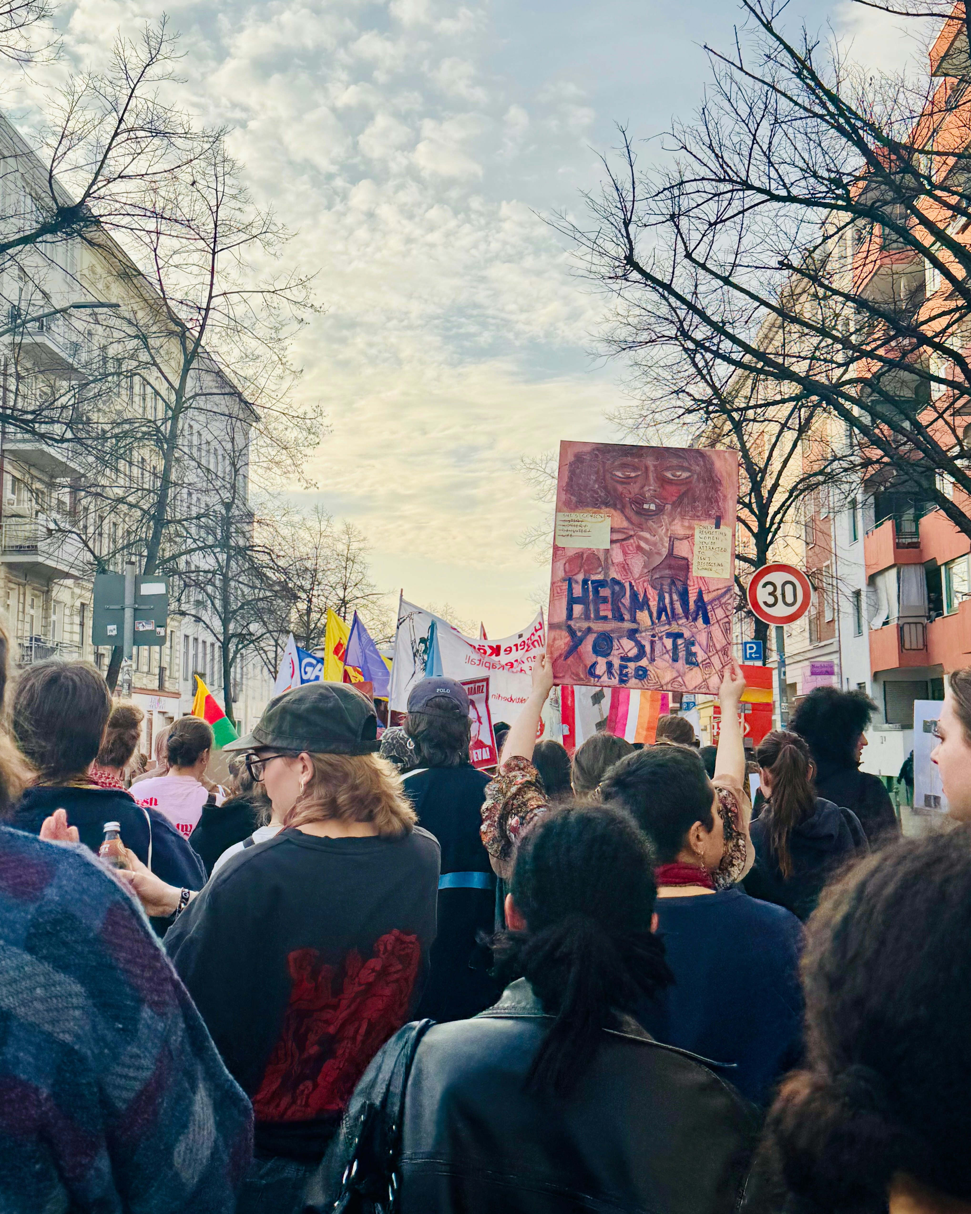 Des gens se rassemblaient dans une rue en tenant une pancarte de protestation.