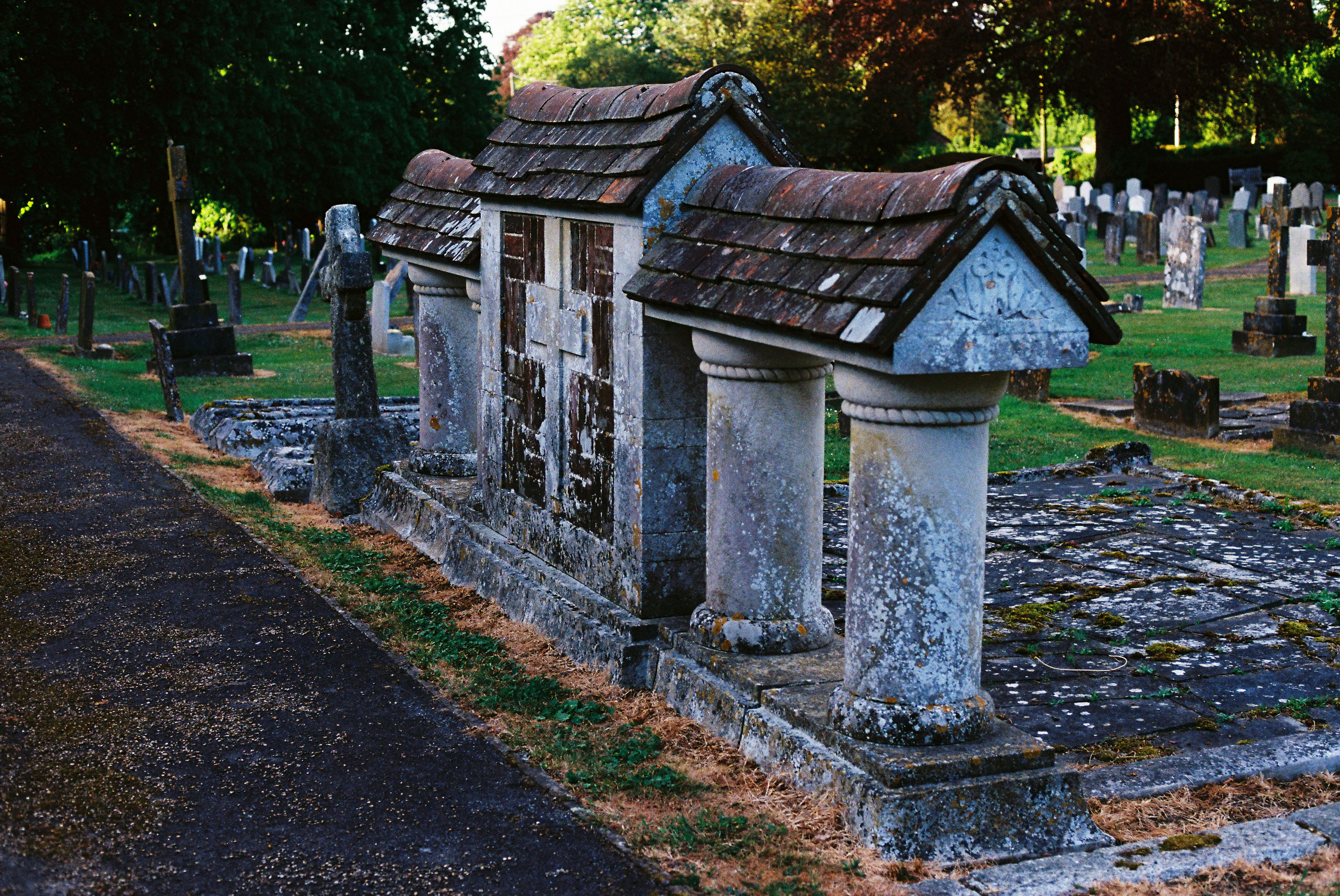 Tumbas antiguas de piedra con techos en un cementerio histórico.