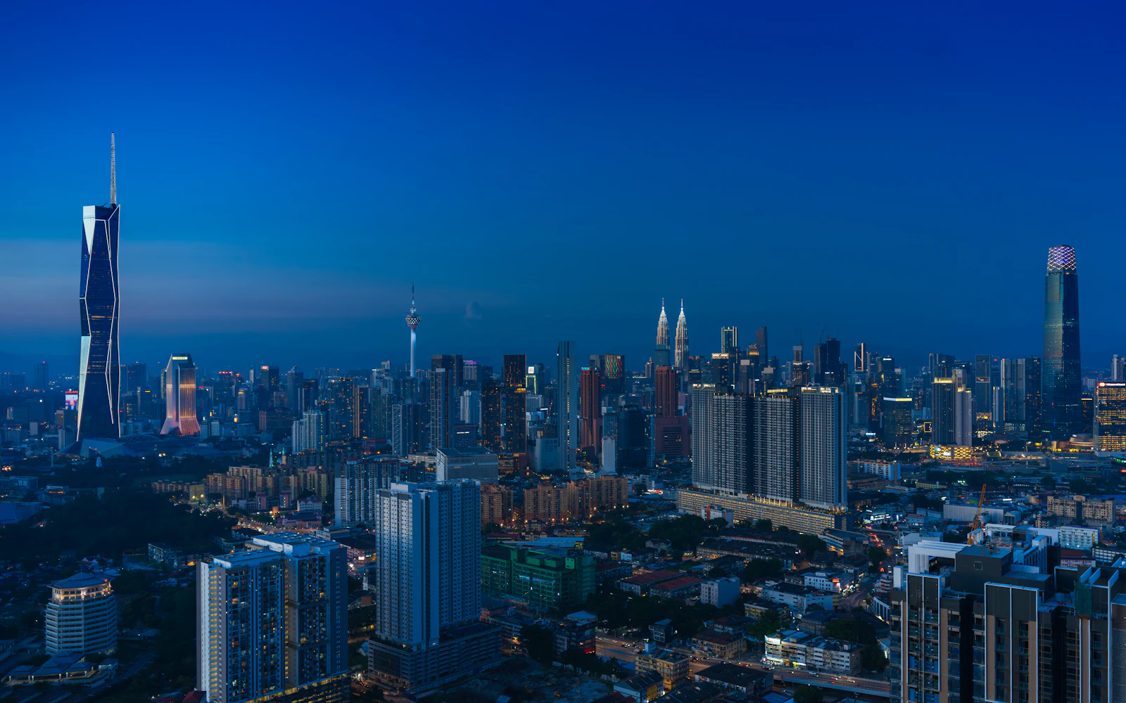 A modern city skyline with illuminated skyscrapers at twilight, Kuala Lumpur, Malaysia