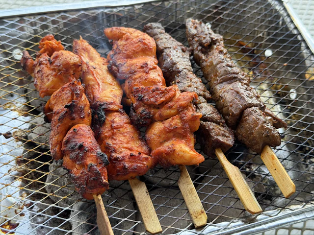 Chicken and beef skewers over coals