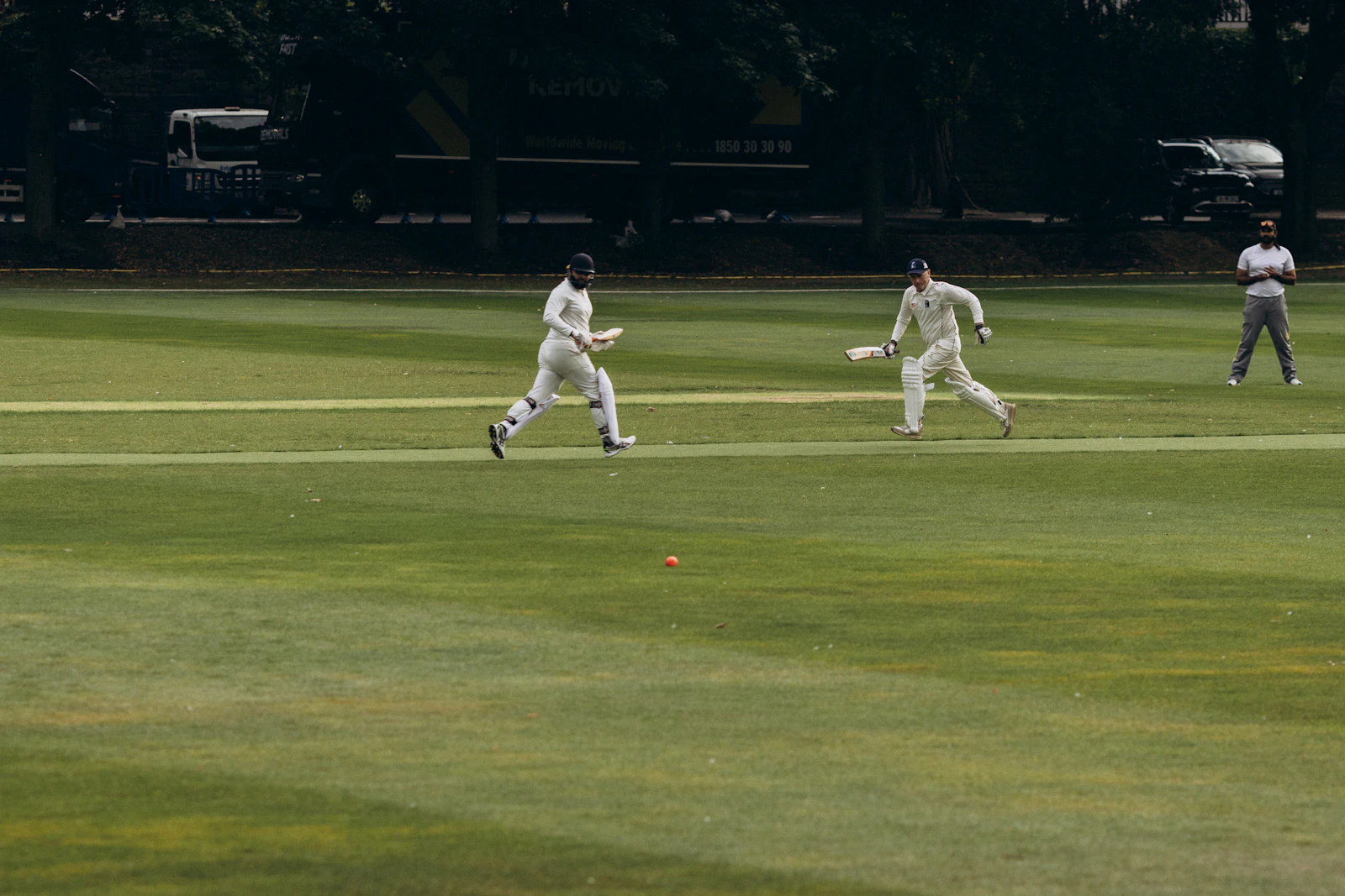 Two cricketers running between the wickets during a game