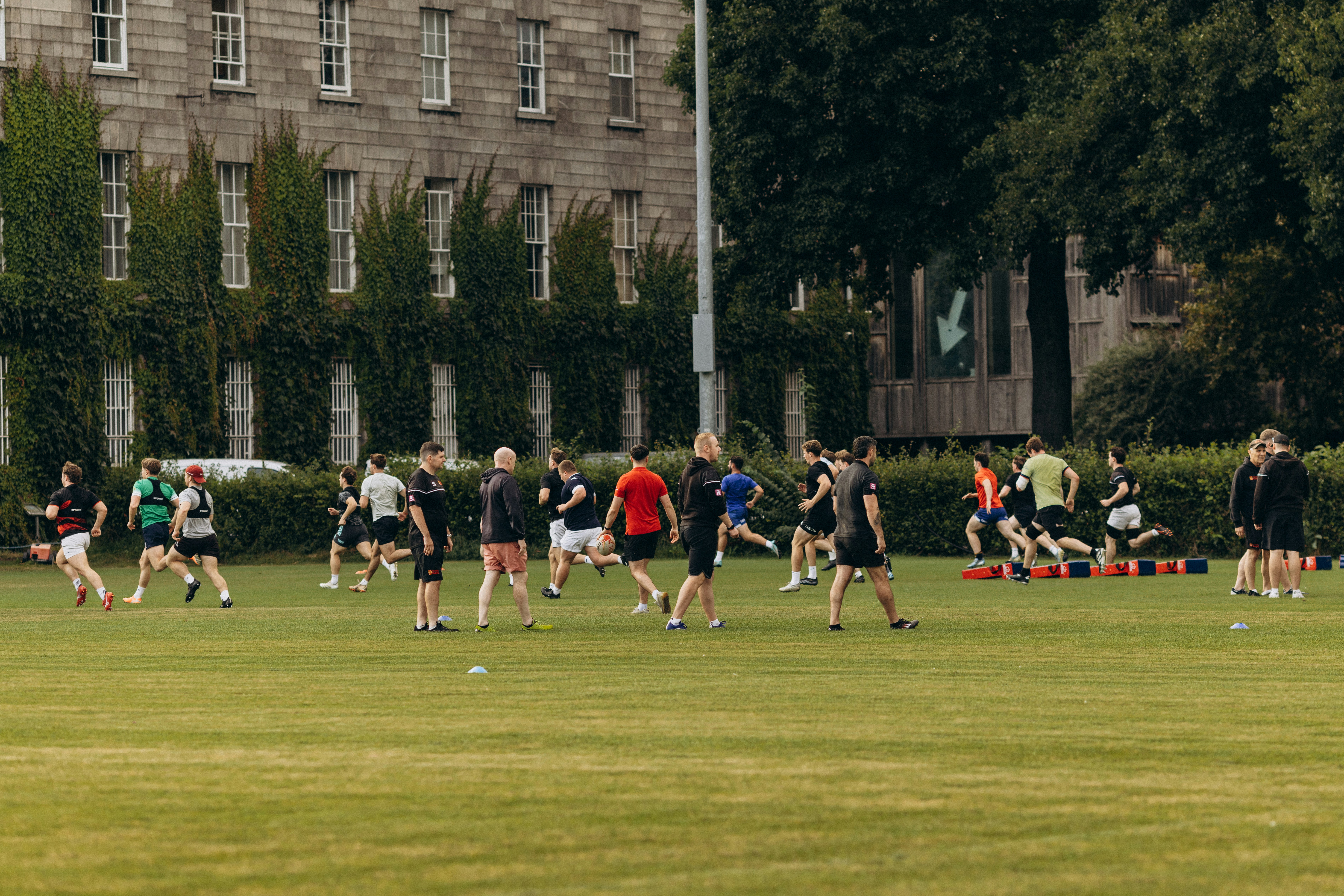 People exercising on a grassy field near an old building