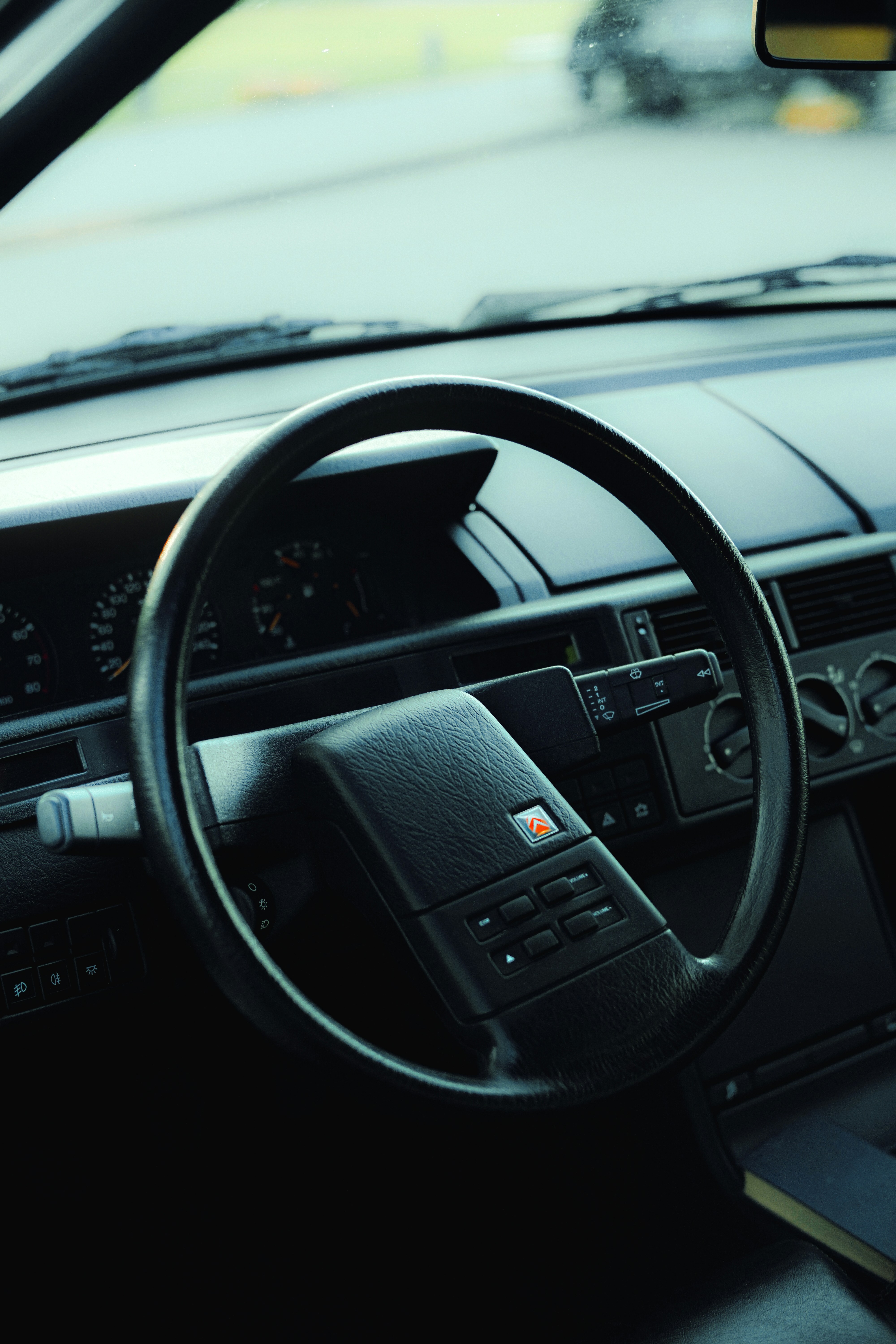 Dark car interior featuring a steering wheel and dashboard.