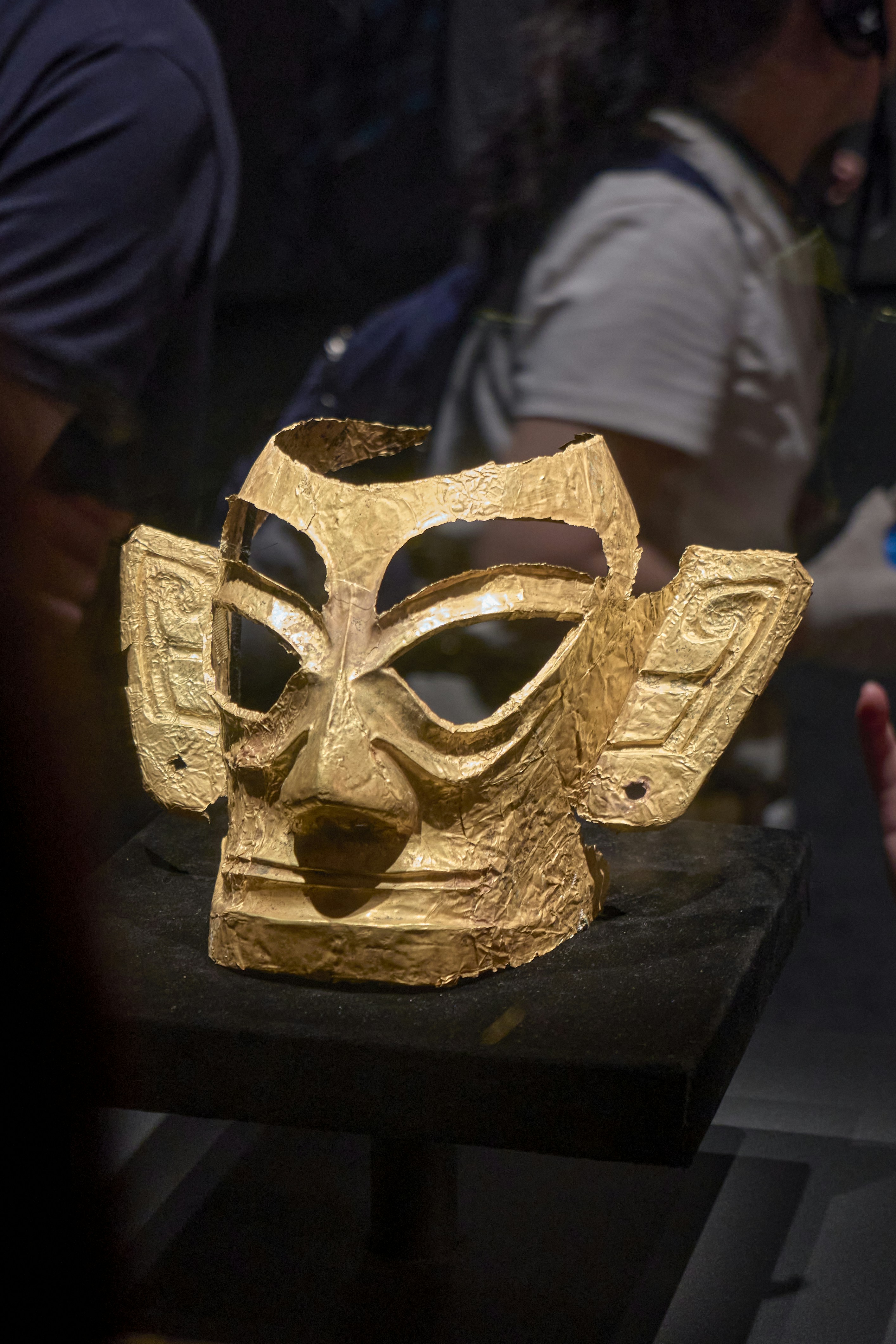 Uma máscara dourada antiga exposta em uma exposição de museu.