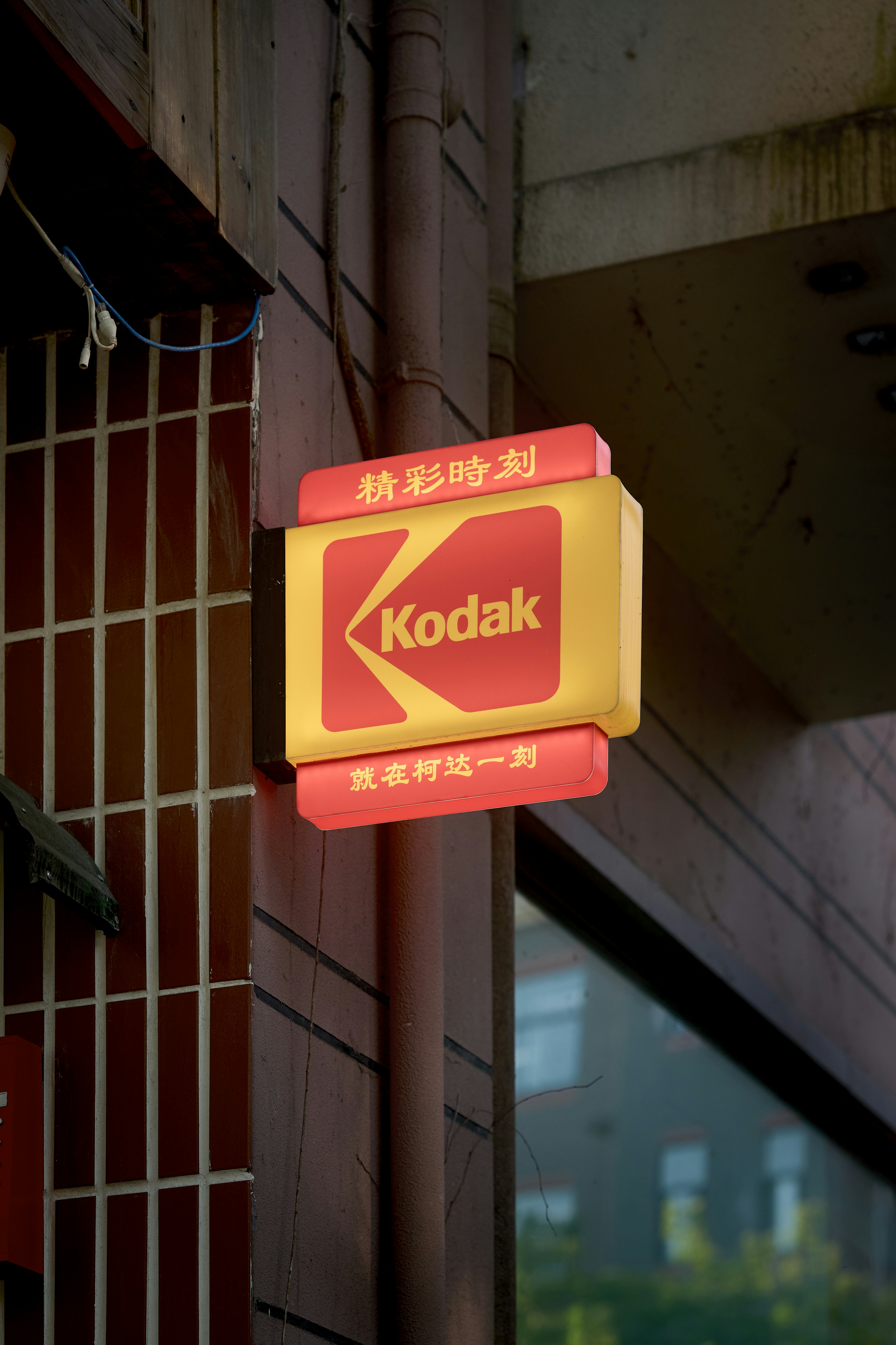 Placa Kodak amarela e vermelha com texto em chinês.