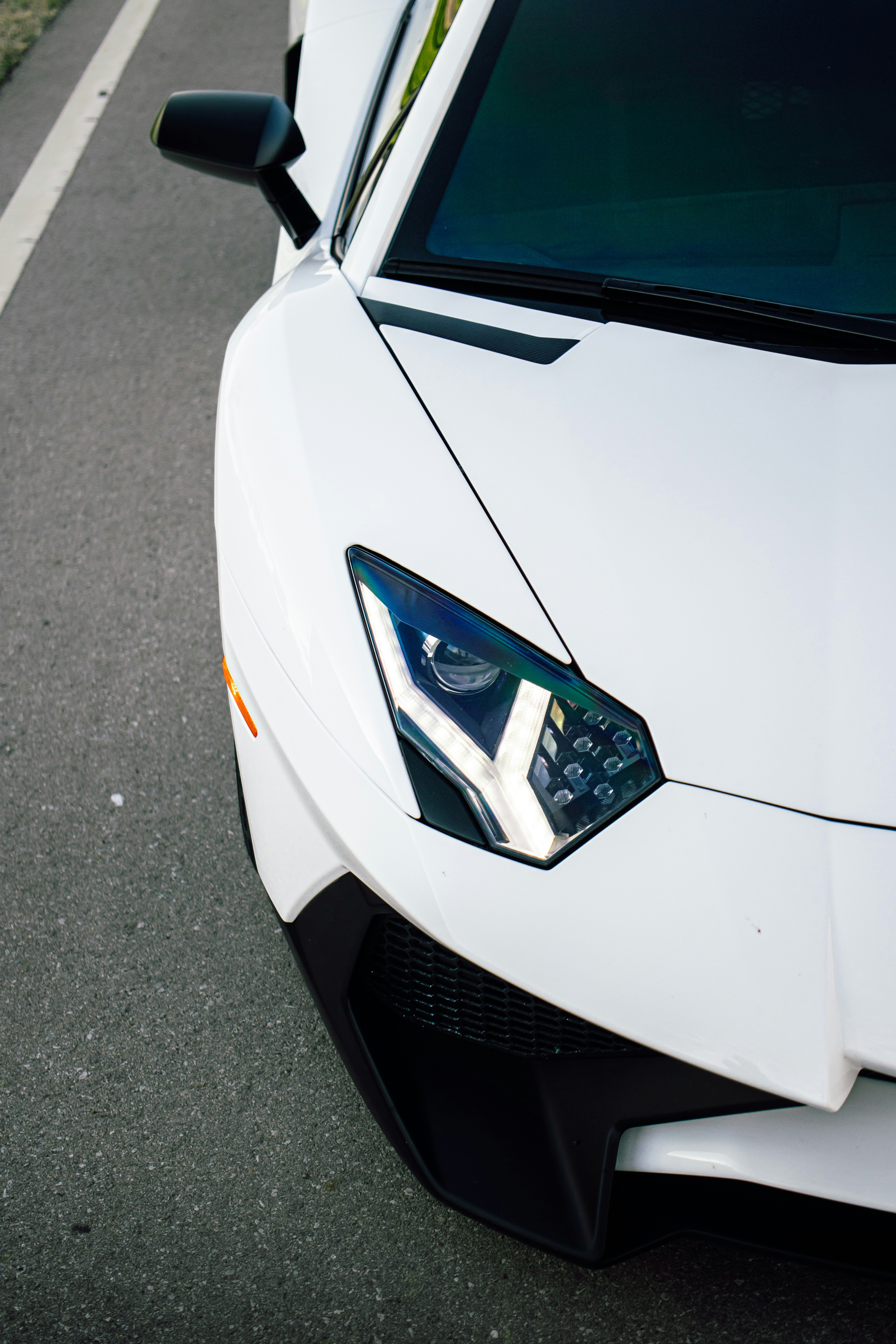 Mobil sport lamborghini putih diparkir di jalan aspal