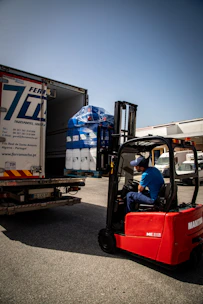 Forklift loading pallets of goods into a truck.