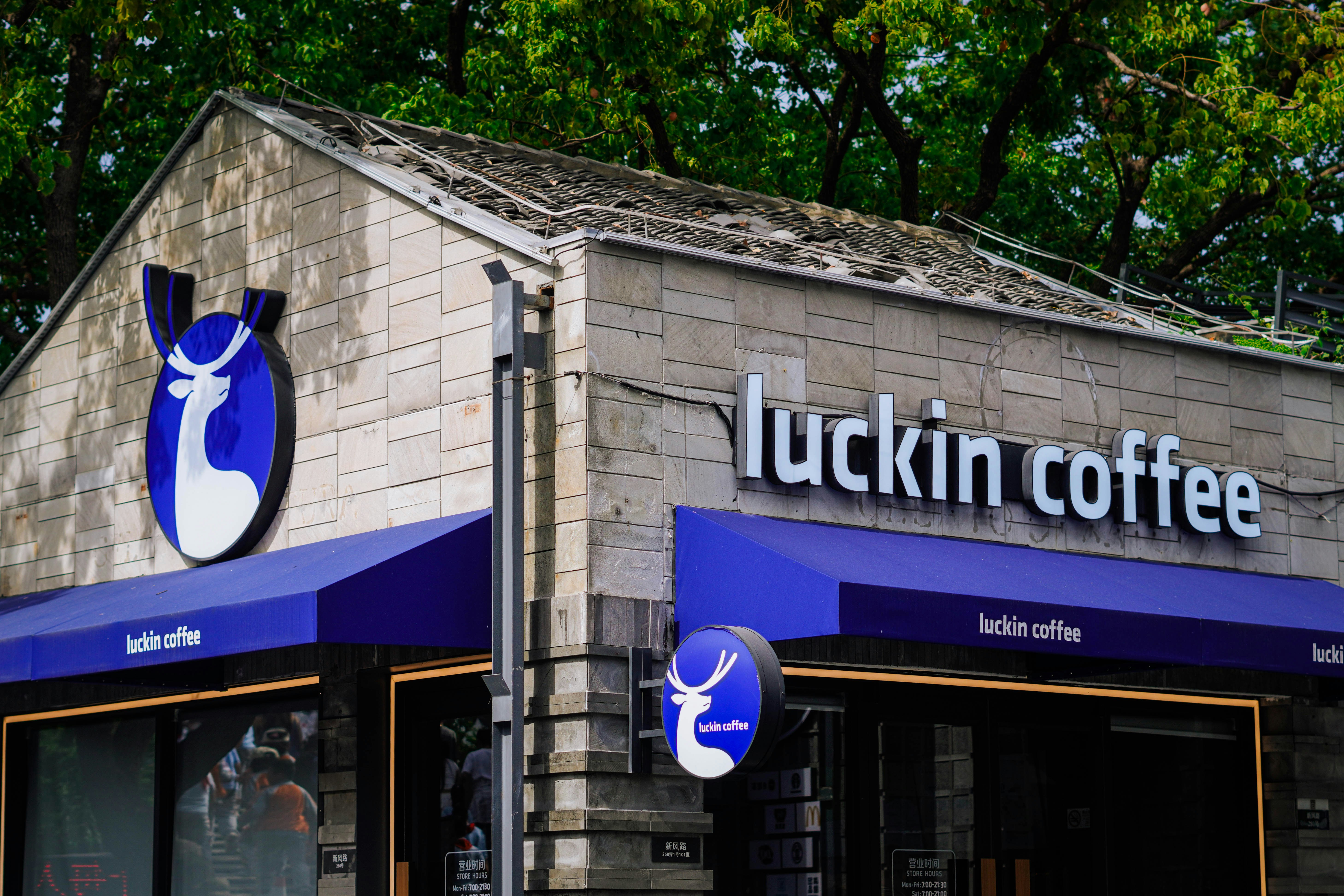 Un edificio di un negozio di caffetteria luckin con il suo logo blu.