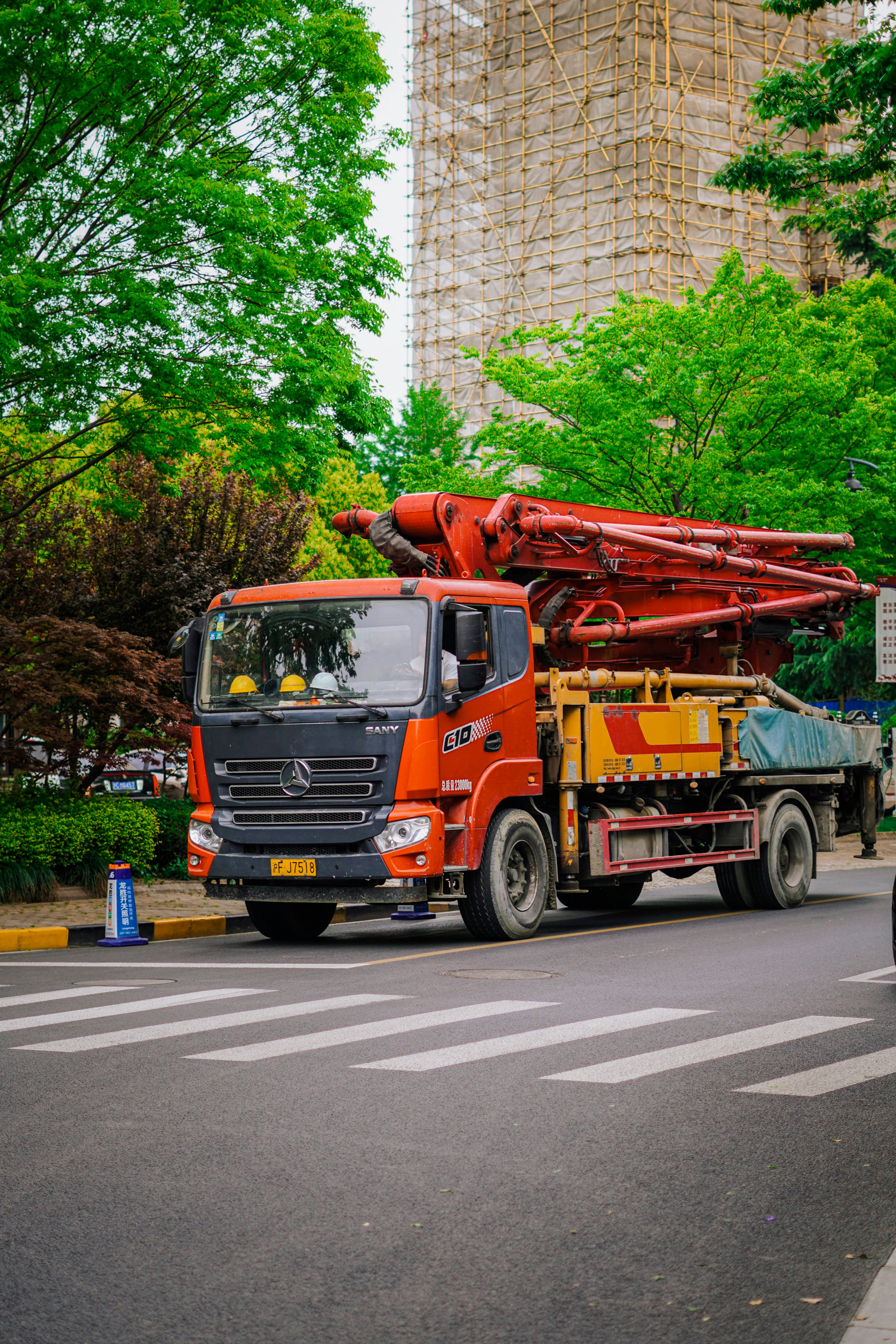 Un camion-pompe orange en béton garé dans une rue de la ville.