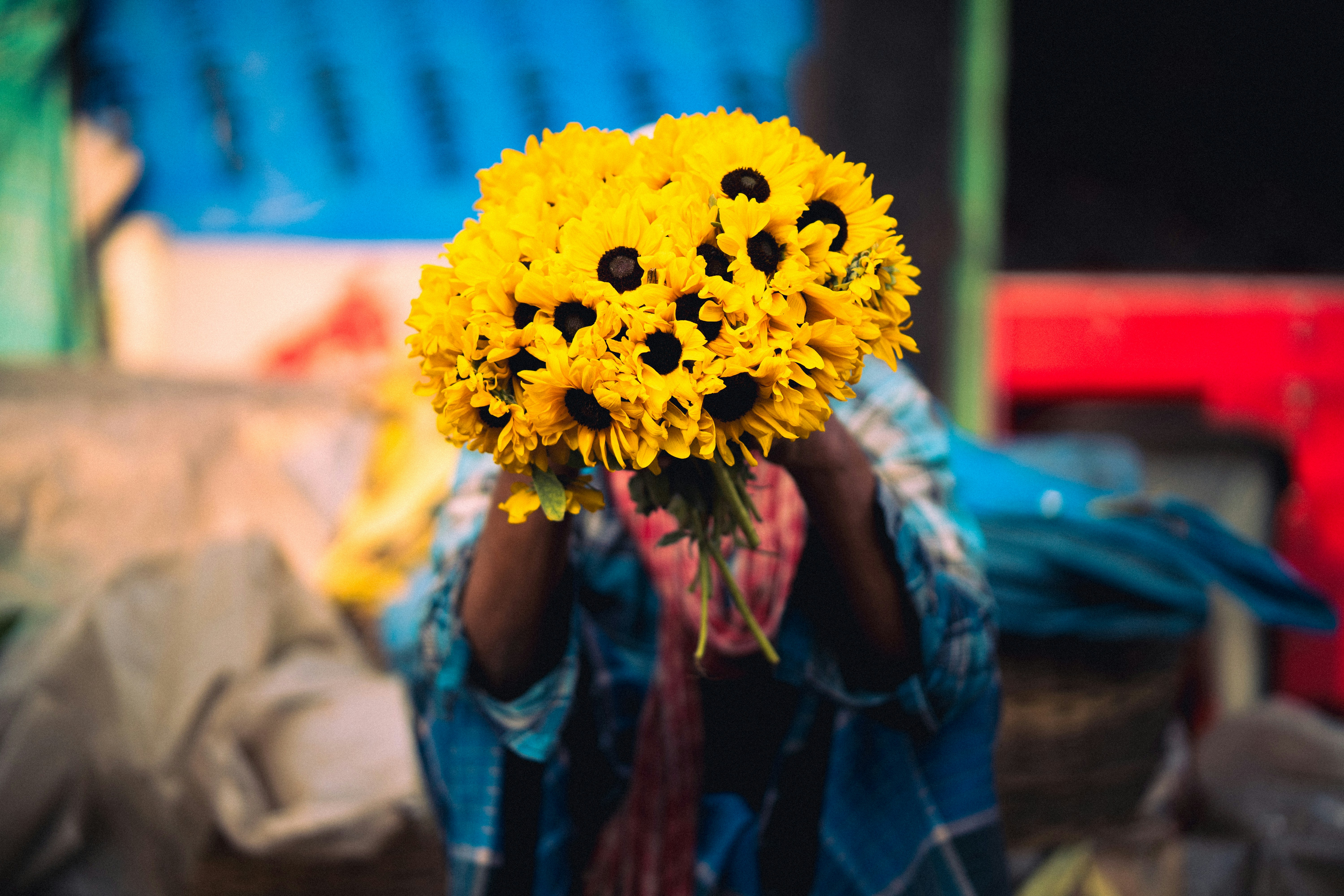 Person holding yellow sunflowers, obscuring their face. photo – Free ...
