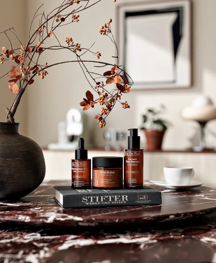 Skincare products and a book on a marble table.
