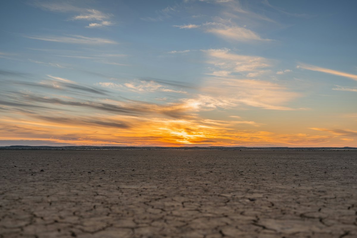 Vast cracked desert wasteland at dusk