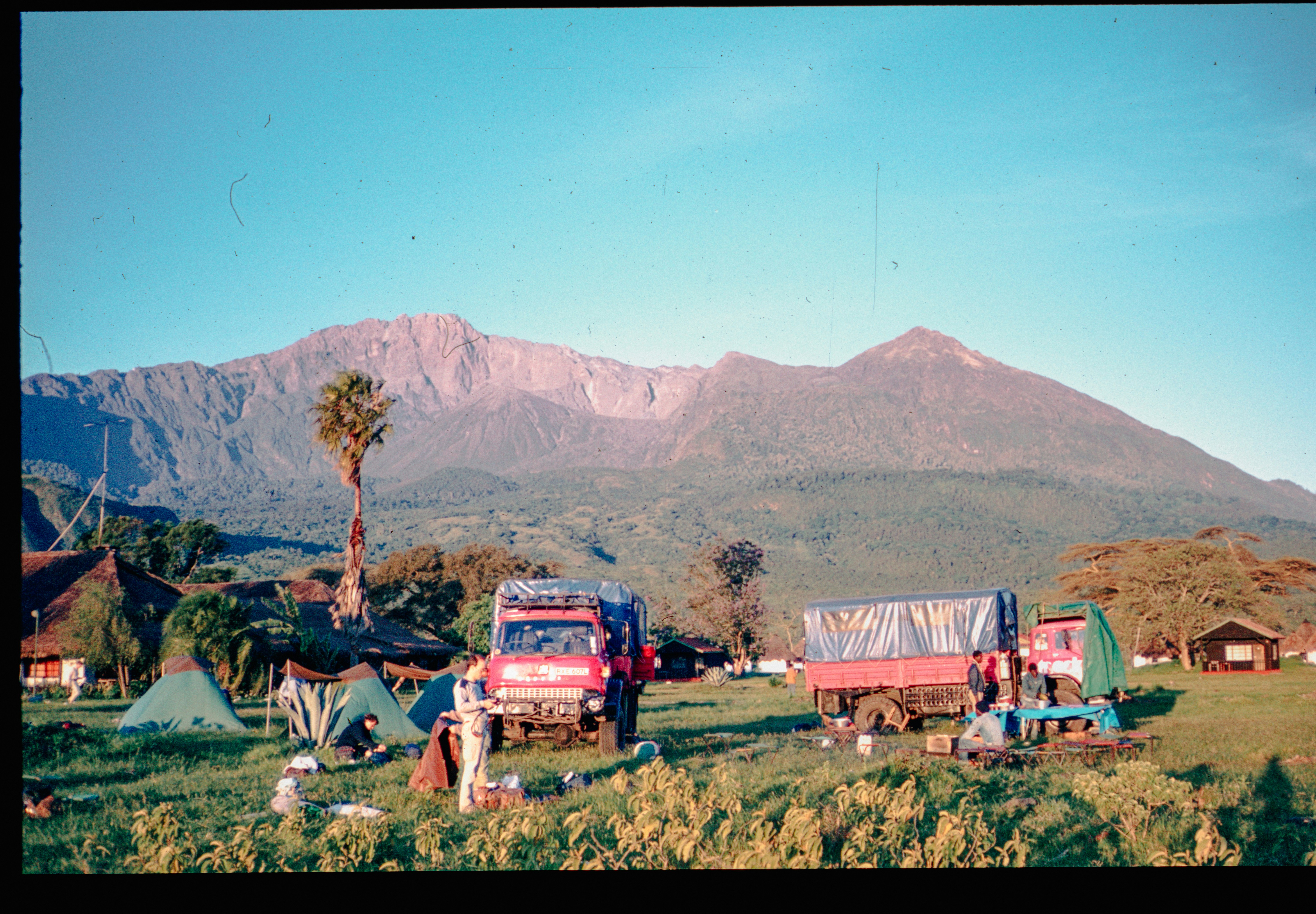 Perkemahan dengan truk dan tenda sebelum gunung besar.